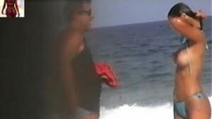Tem uma celebridade nua chamada Nana Gouvea dando os peitos na praia
