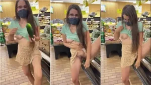 Menina de roupas leves no mercado, se divertindo com um pepino de um jeito bem íntimo
